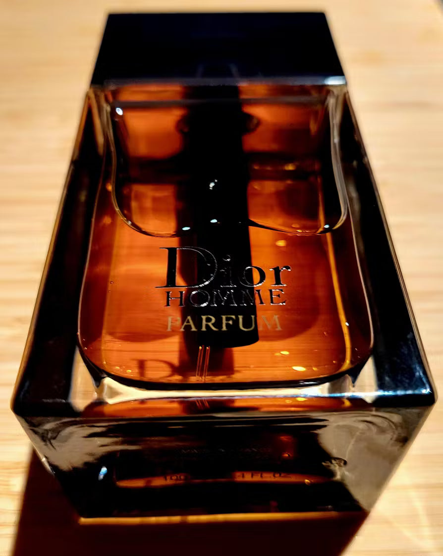 Dior Homme perfume bottle in a reflective box on a wooden surface