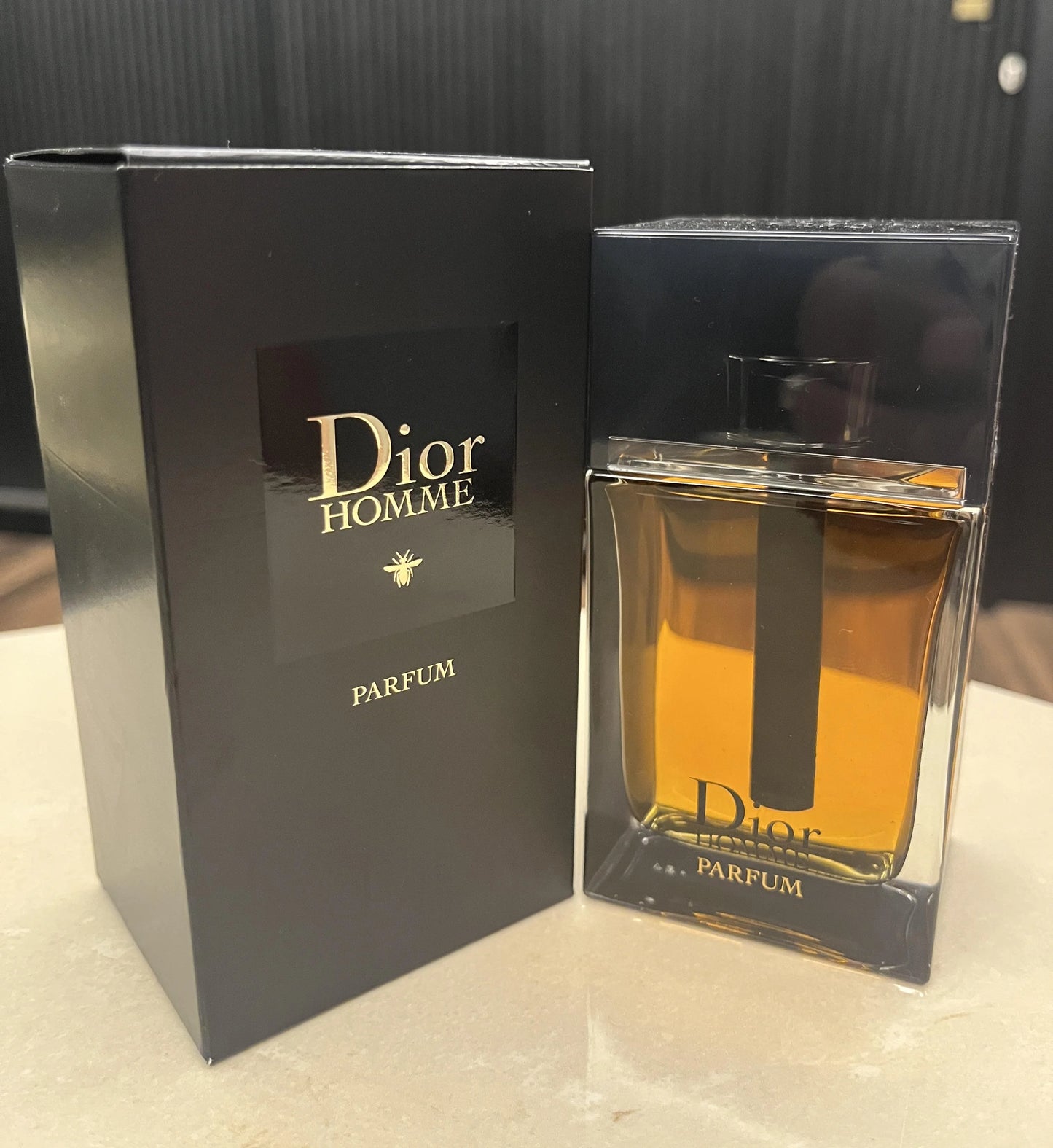 Dior Homme parfum bottle and packaging on a neutral background
